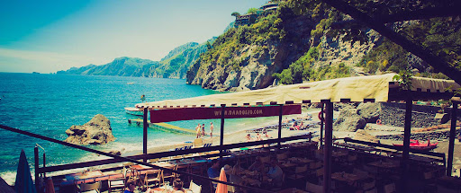 Da Adolfo beach club dock and restaurant terrace with bohemian atmosphere