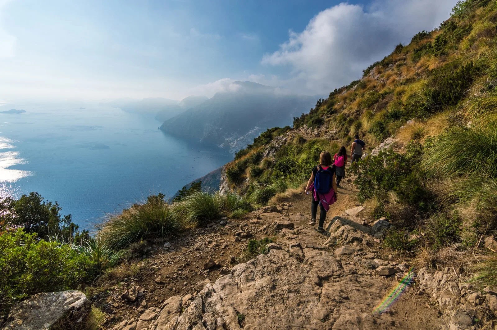 Hikers on the Path of the Gods trail with dramatic Amalfi Coast views below